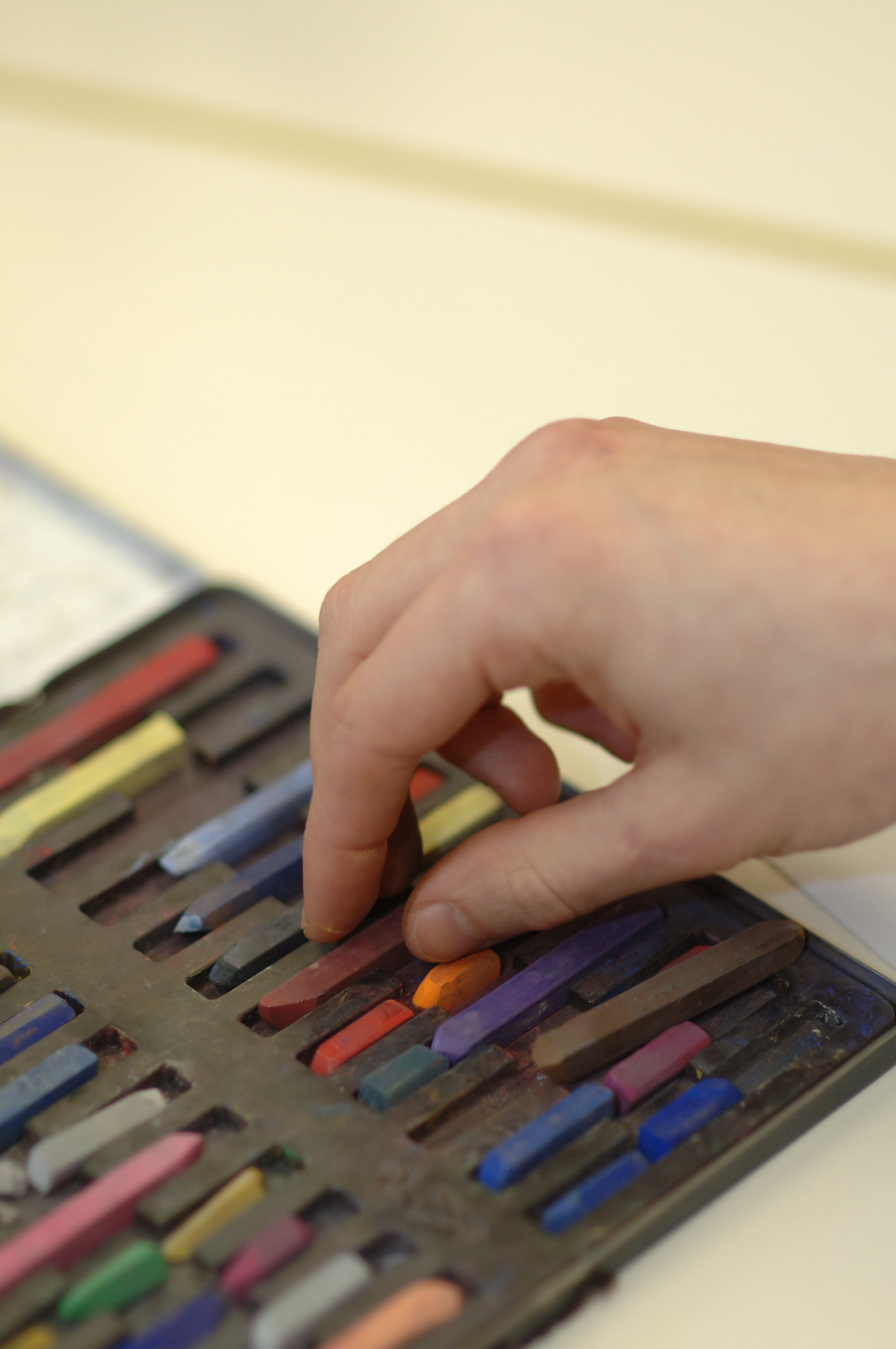 Eine Hand greift zur Malkreide