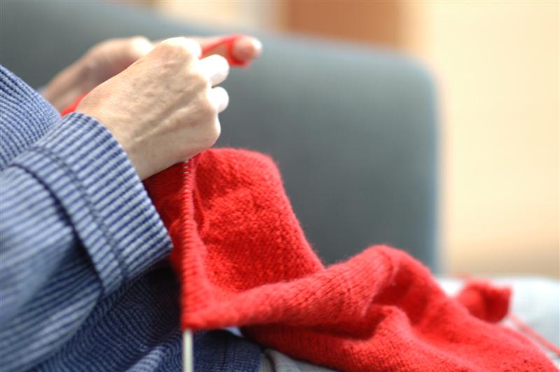 Hände, die stricken